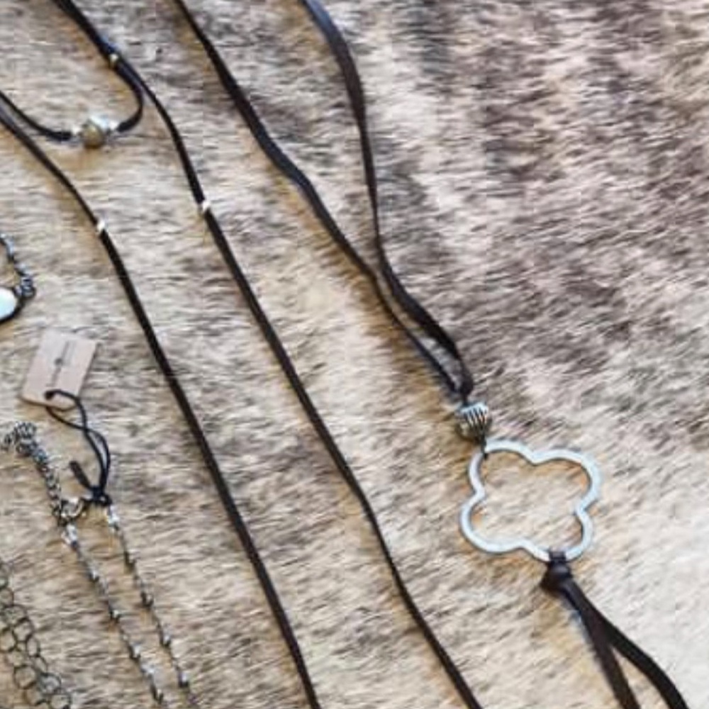 Elegant brown leather with natural stones w/ silver colored rustic centerpiece.
